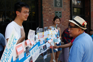 CAAAV volunteer shares "History of Organizing" timeline at CTU's Take Back Chinatown event.